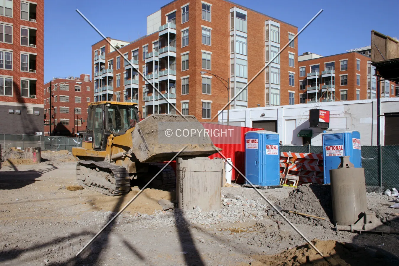 Front-end loader resting its scoop on a caisson top