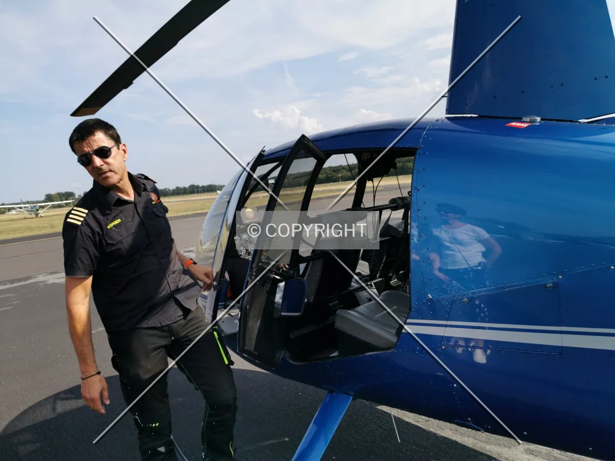 A helicopter pilot opening a door