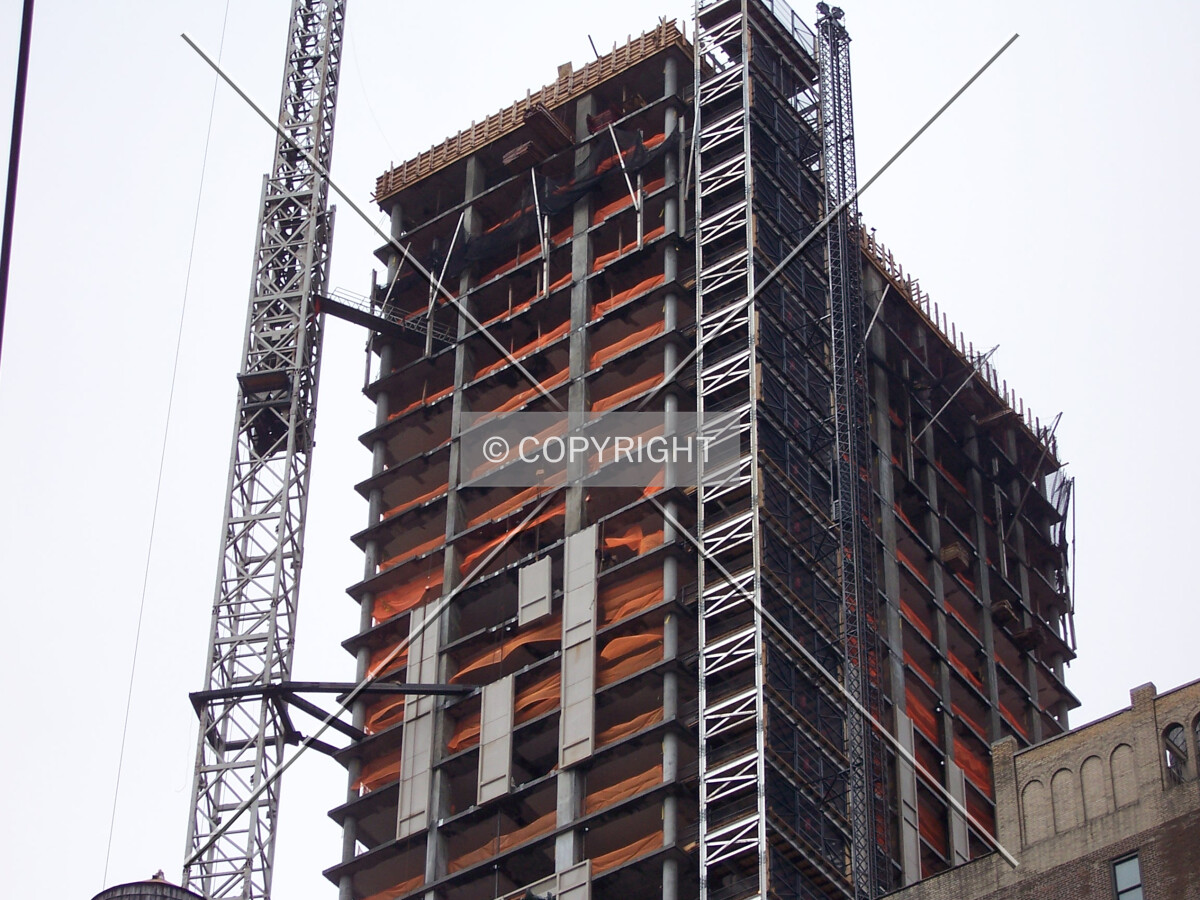 Hoisting a section of precast concrete into place on the east façade of the tower