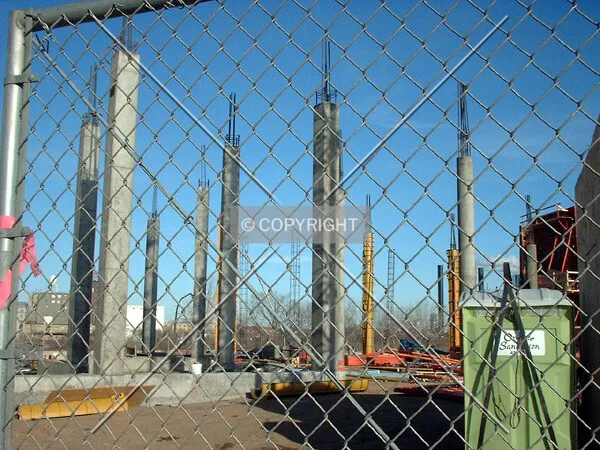 Reinforced concrete supports through the construction fence