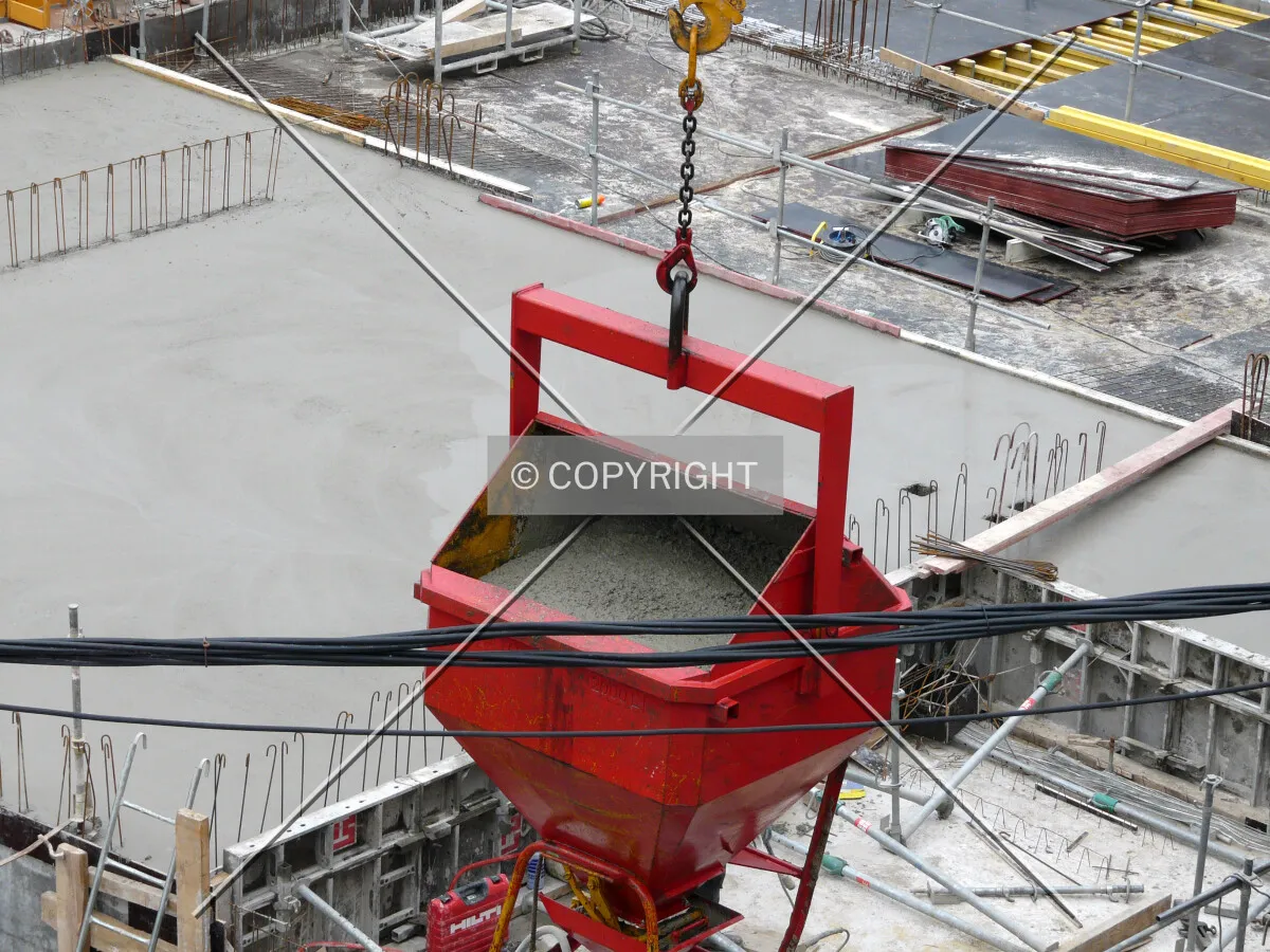 Concrete bucket ready to be used to pour a wall on the underground floor