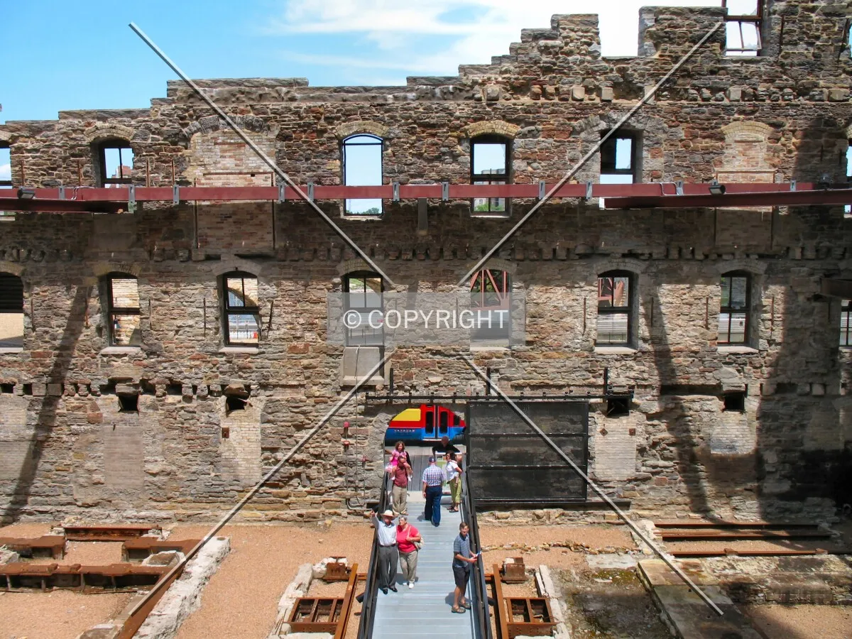 Visitors entering the ruins courtyard from West River Parkway