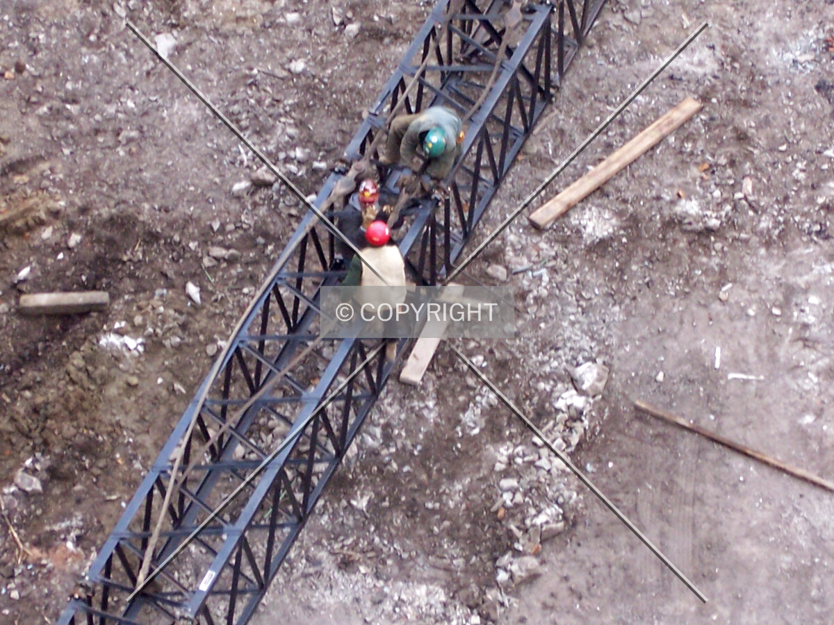 Workers assembling the boom of the pile driving crane