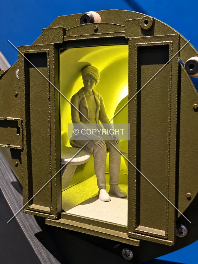 A minature replica of a person inside one of the pods that take visitors to the top, located in the lower level, Sunday, October 4, 2026