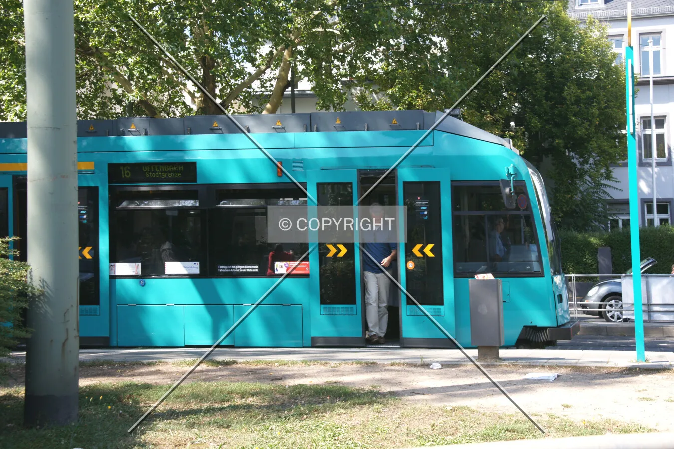 A man is leaving a green tram train