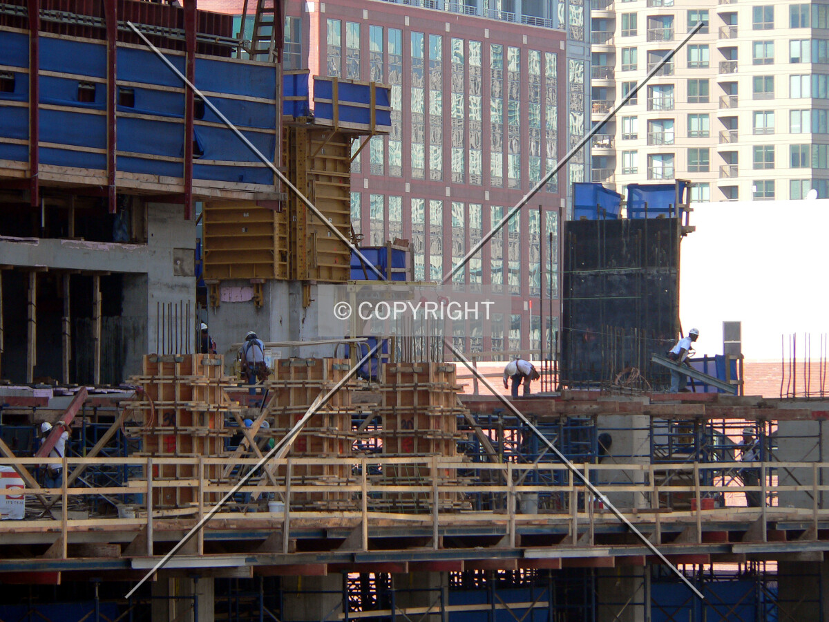 View to the northwest as workers work on the next level of the parking structure