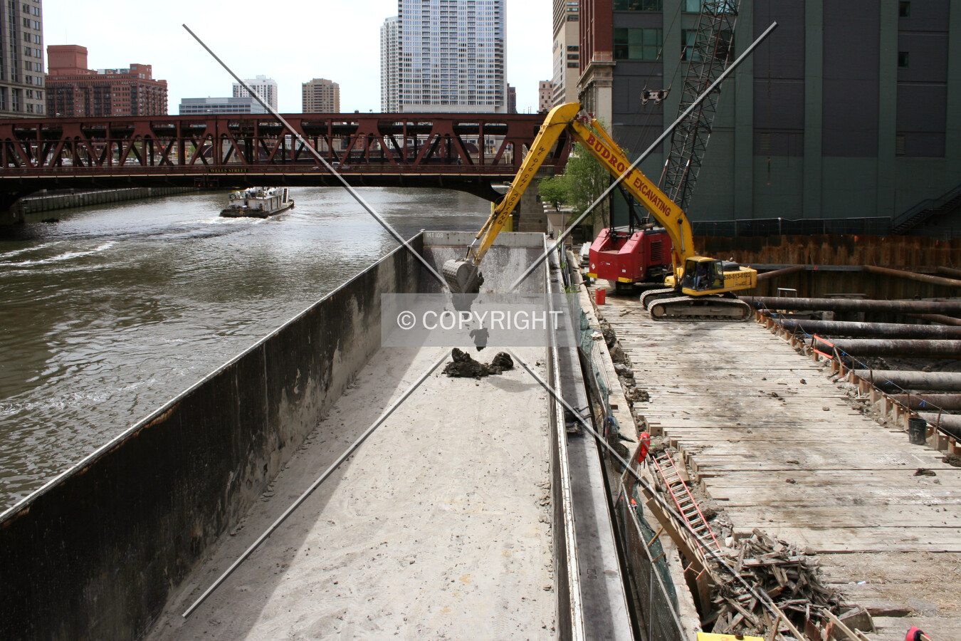 Second shovelful of earth in the new barge; the departing towboat is in the background