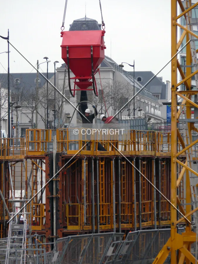 Workers pouring a concrete wall on the east side