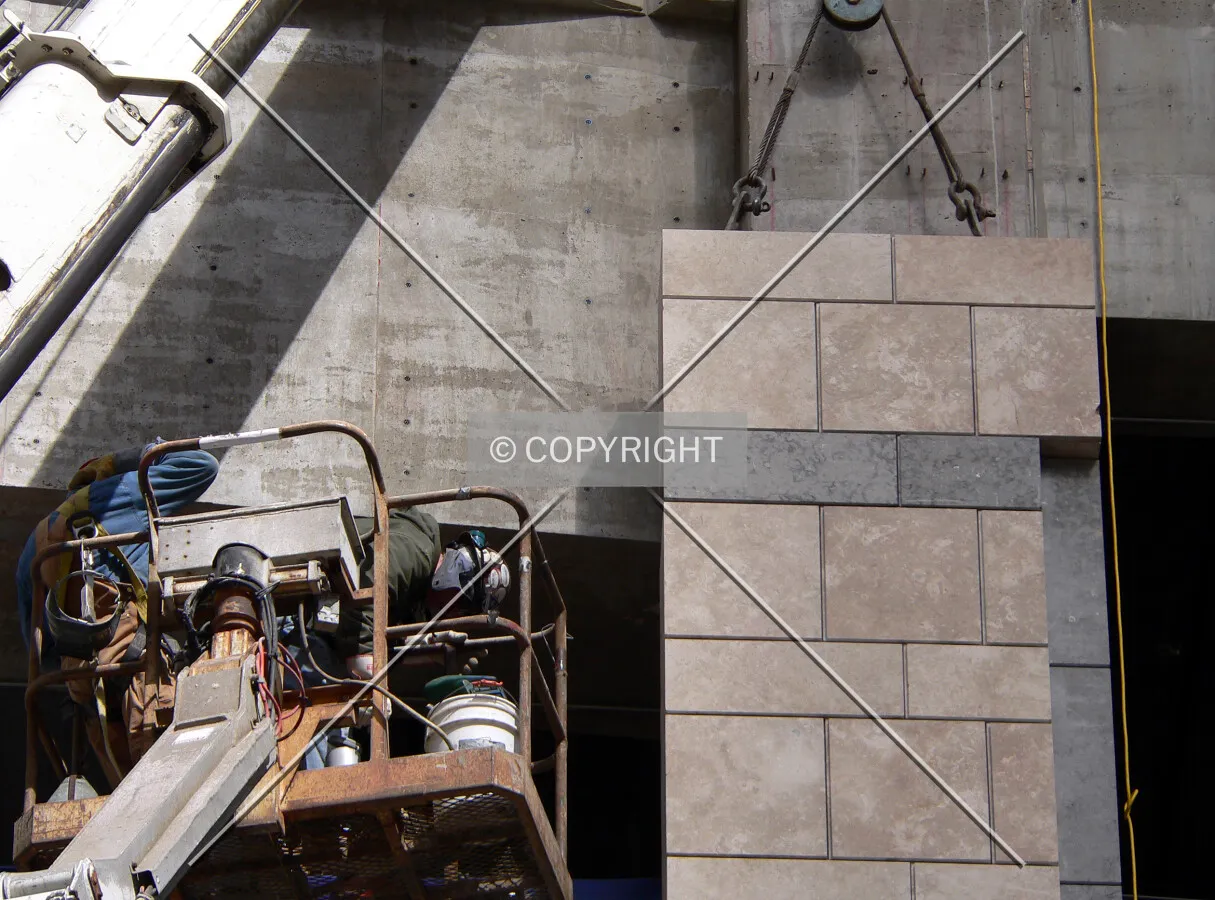 Stone veneer panels being installed at the base
