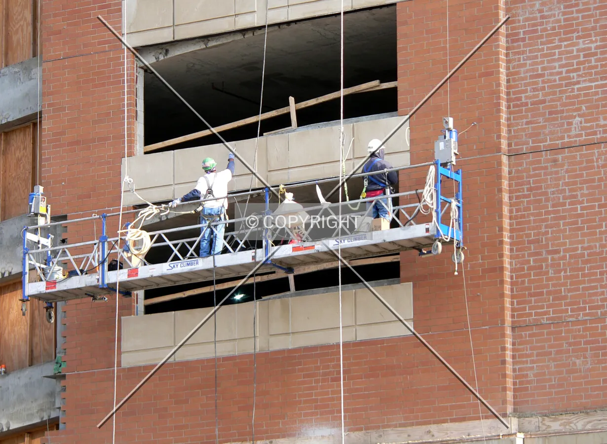 Workers cleaning the brick of mortar residue