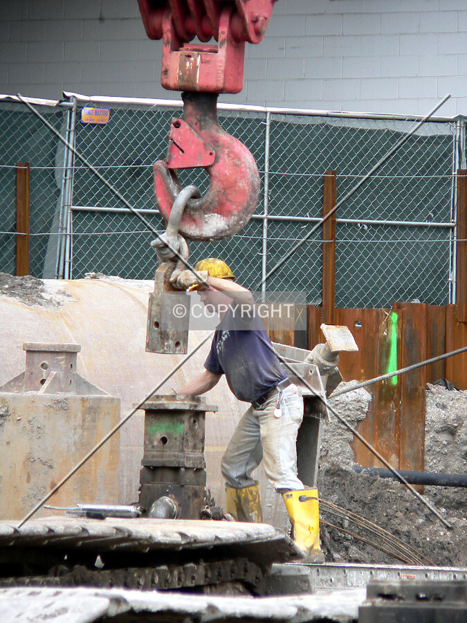 Attaching the crane to raise drilling equipment out of a caisson hole