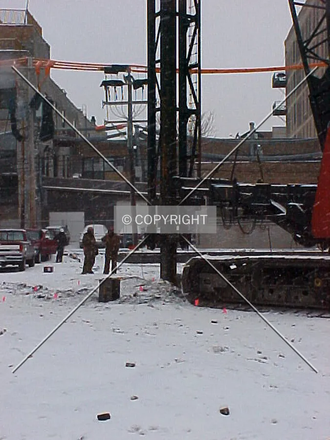 A steel pile in place being driven into the ground