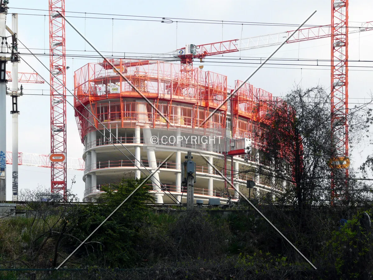 The tower rising behind the rail track of the RER C