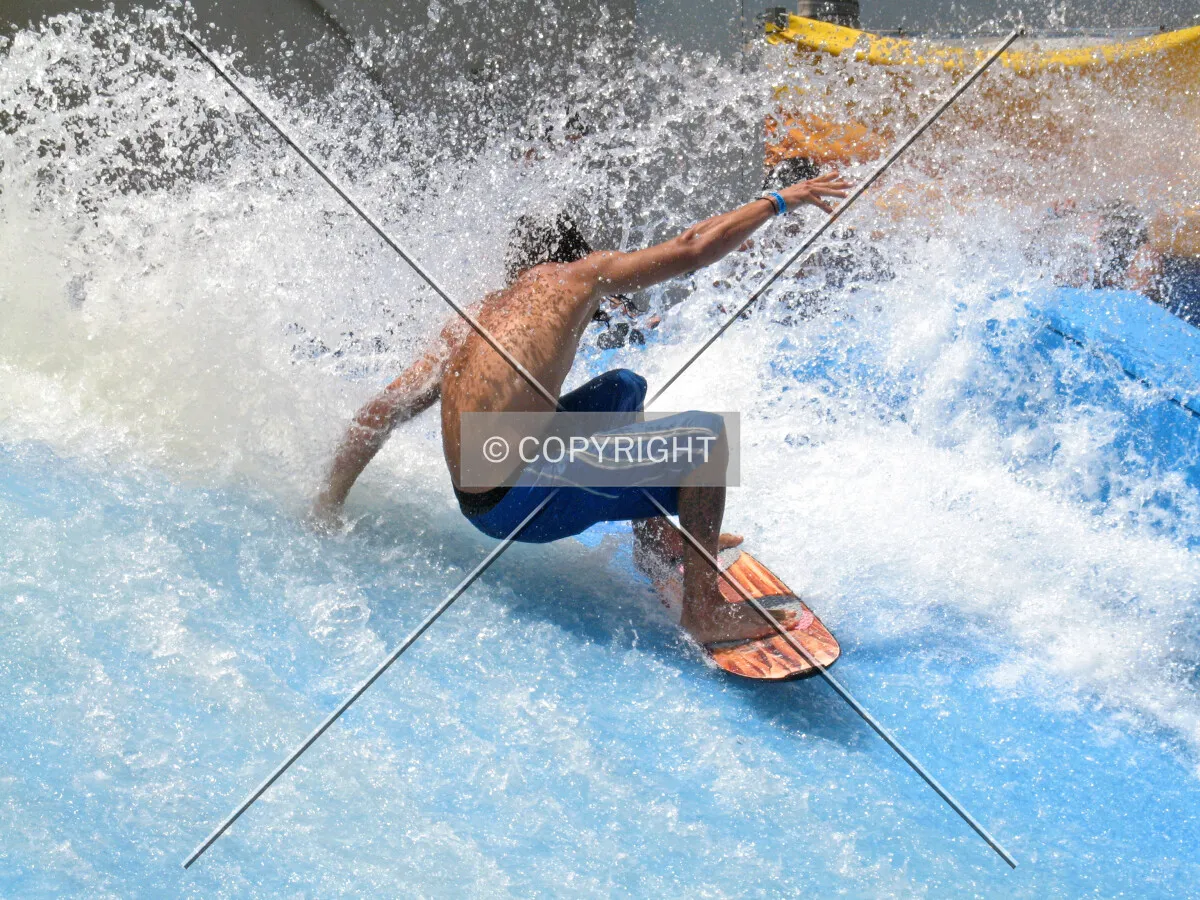 A surfer splashes spectators at the 'Wave House' at Belmont Park