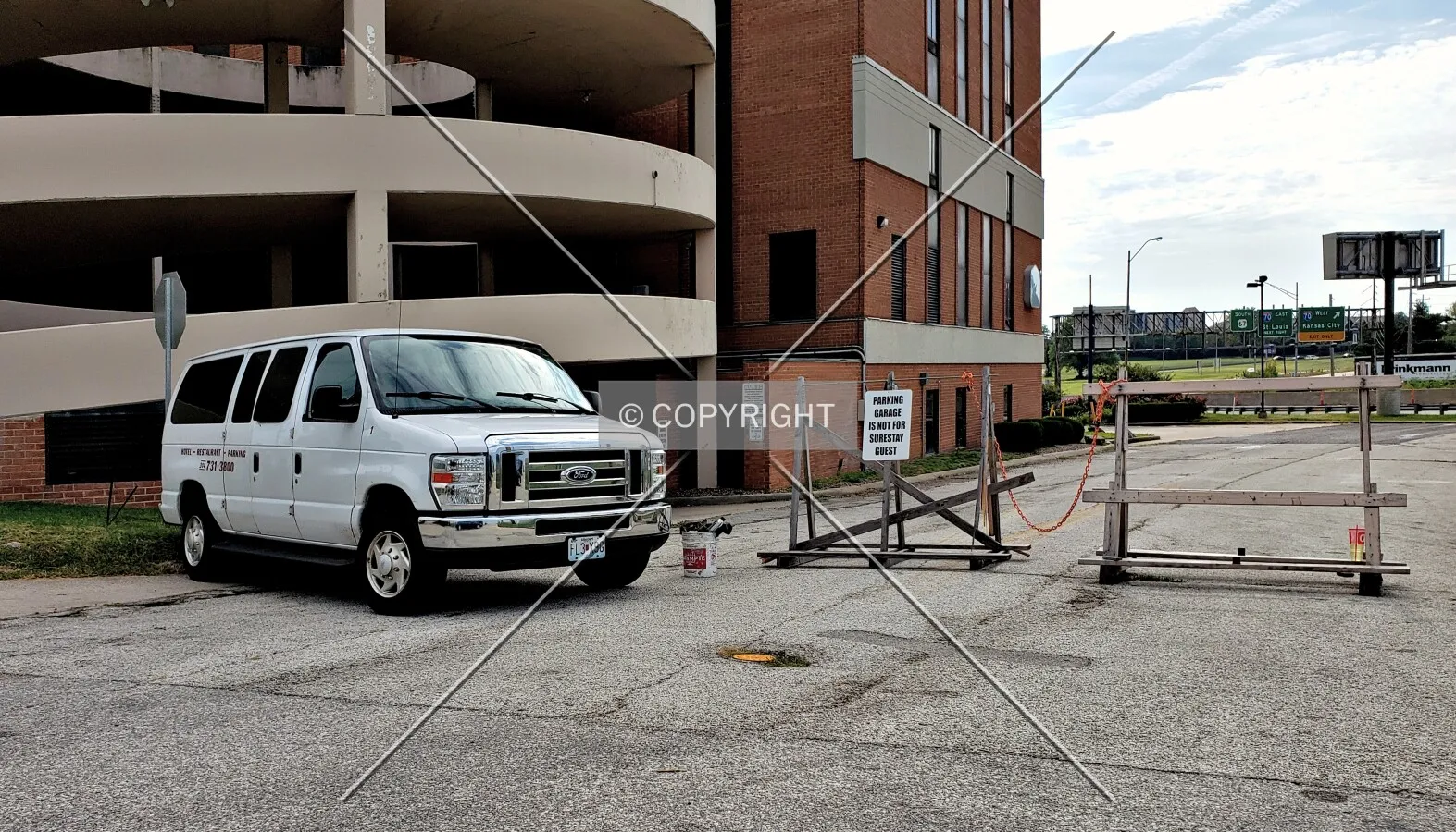 Abandoned hotel van and barricade blocking the parking lot; September 21, 2019