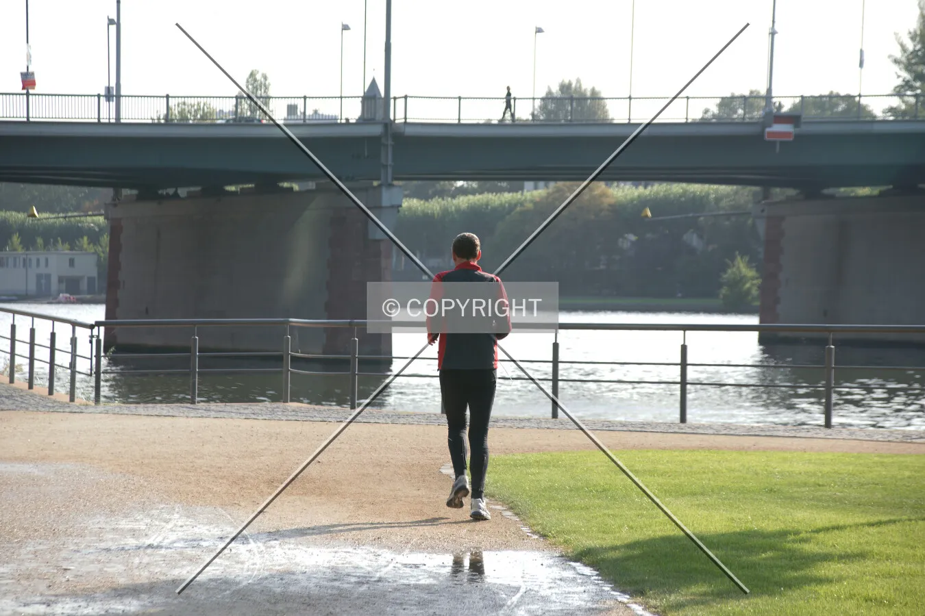 A man is jogging on a river shore