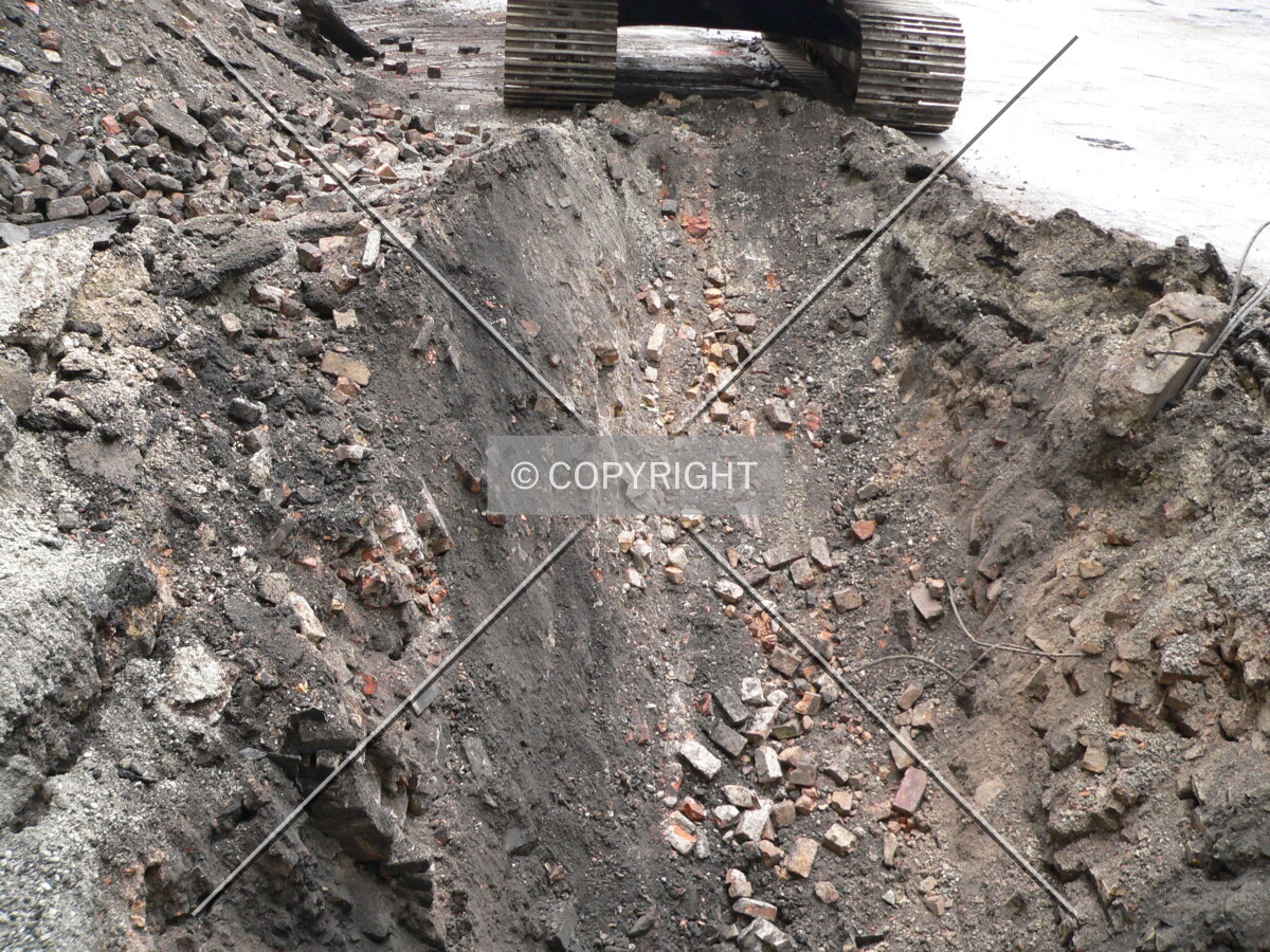 A small excavated portion of the parking lot with debris visible