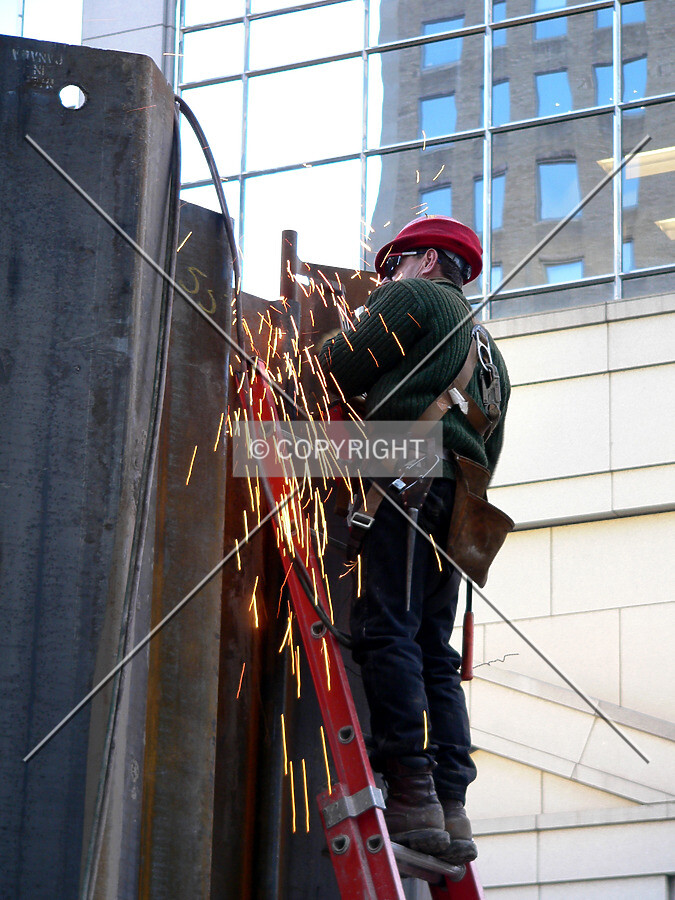 A worker cutting steel sheeting with a torch