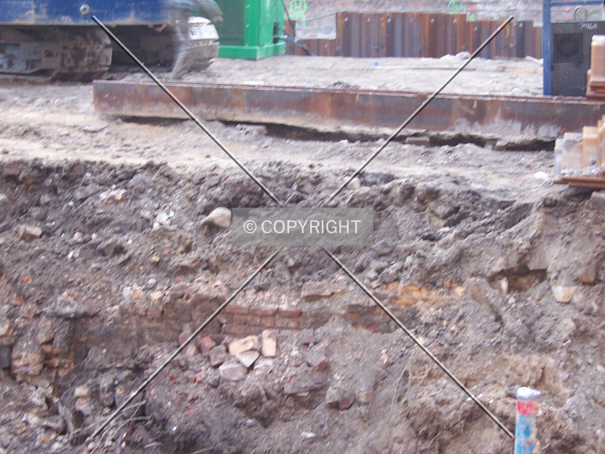 An old brick foundation wall has been unearthed in the trench in the foreground, excavated for sheet pilings to be driven into the ground along the Wabash Street (east) side of the site