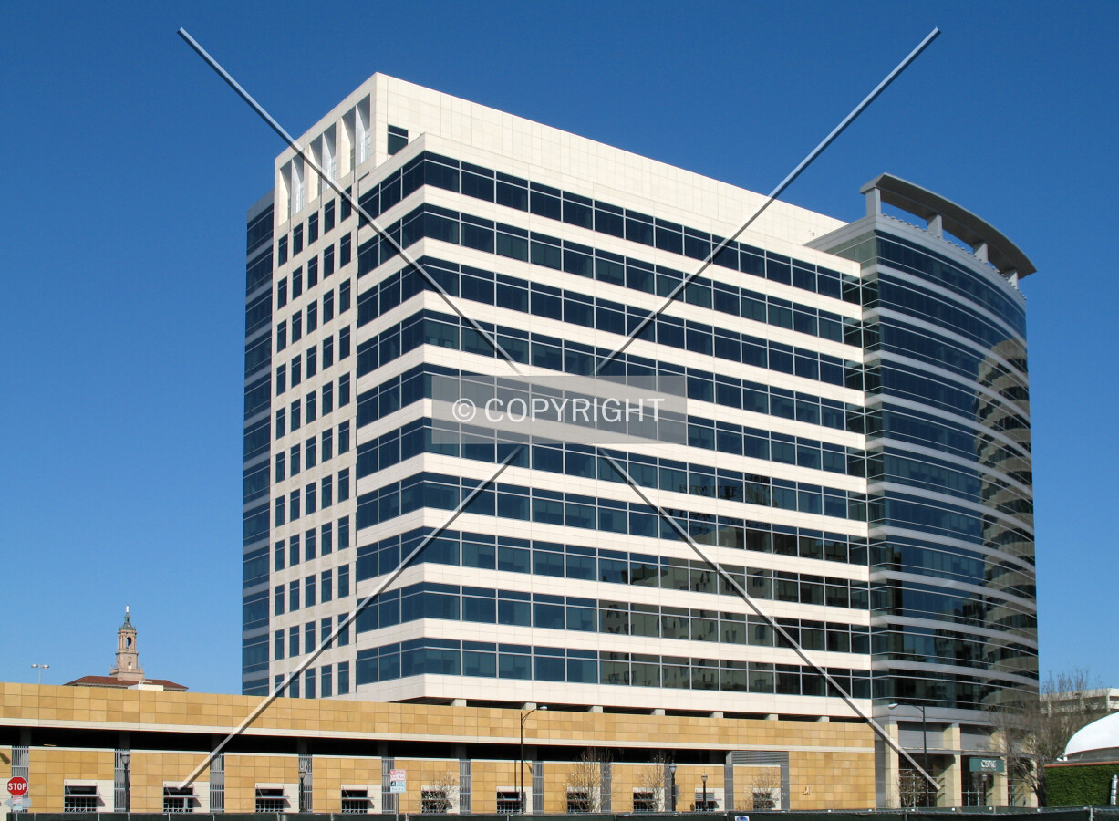 The north section of the tower rises above a parking garage that extends well beyond the perimeter of the tower