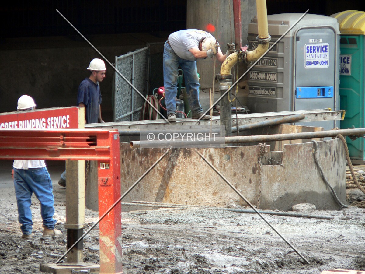 Taking measurements as concrete is poured down a caisson hole
