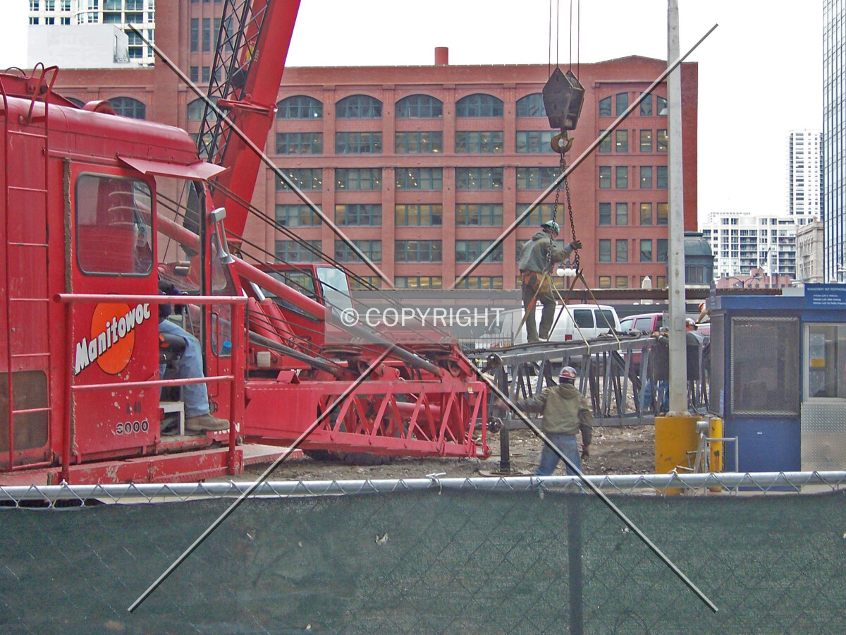 Workers assembling the boom of the pile driving crane