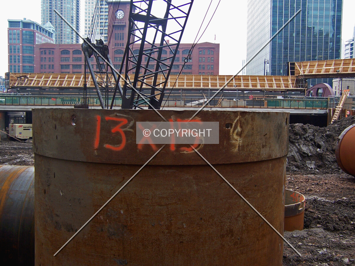 An unused caisson top with the dimensions 13 feet in diameter and 15 feet long painted on the side
