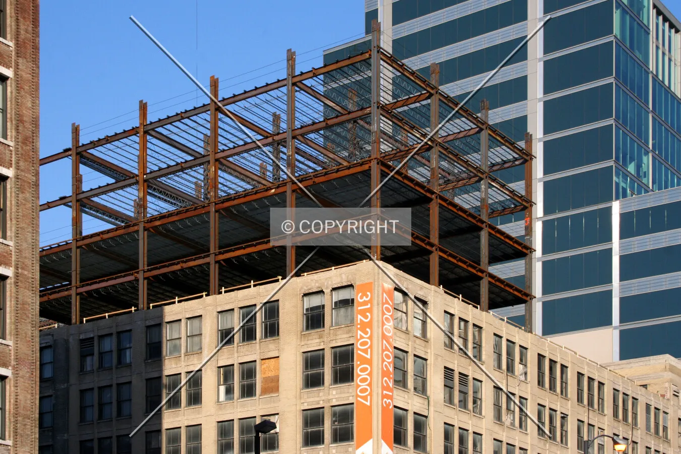 Steel frame rising over the old structure