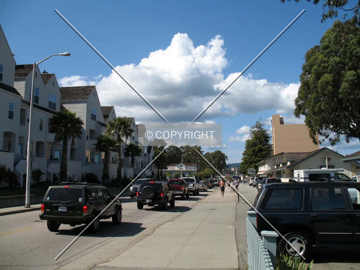 Looking north down West Cliff Drive with a procession of cars heading to the beach and boardwalk