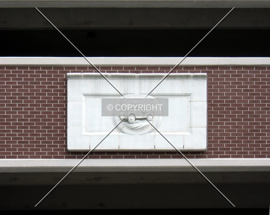 Facade detail showing a medallion from the former garage on this site