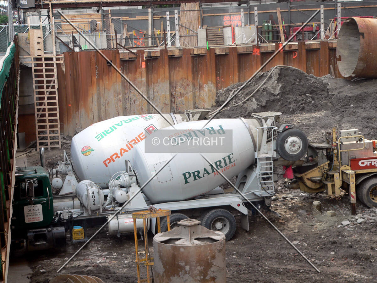 Concrete trucks dumping their load into a concrete pump for a caisson pour
