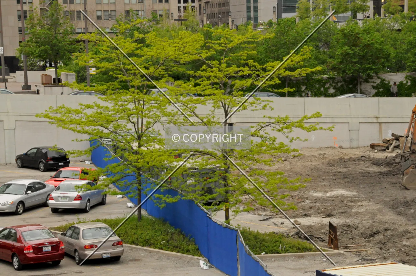 Work limit fence crossing a landscape island, dividing the former surface parking lot from the active parking lot