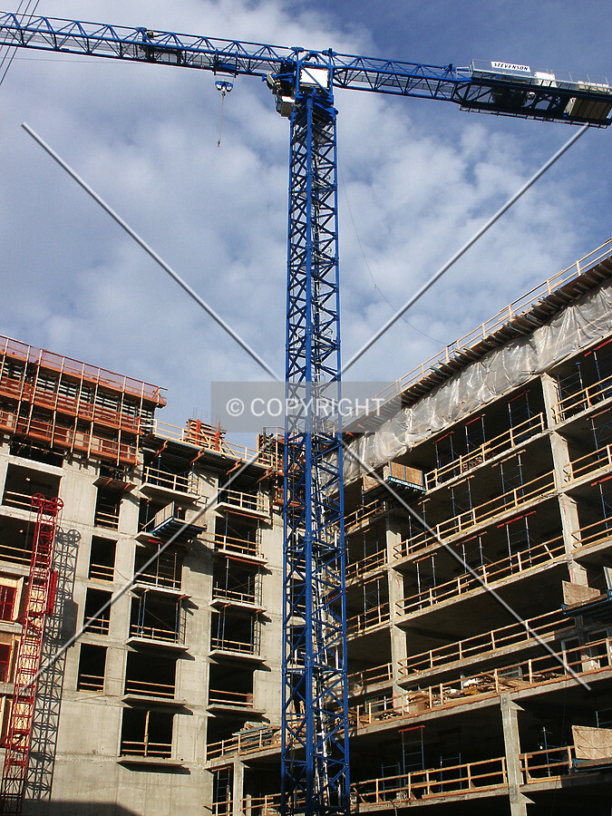 Looking up at the crane from the alley