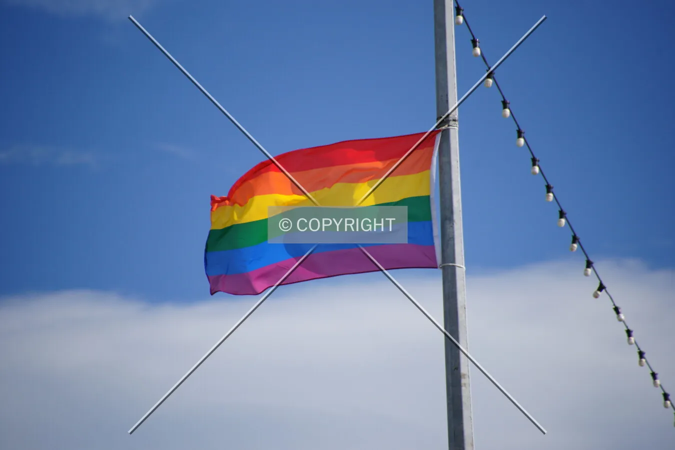 A rainbow flag is flying in the wind
