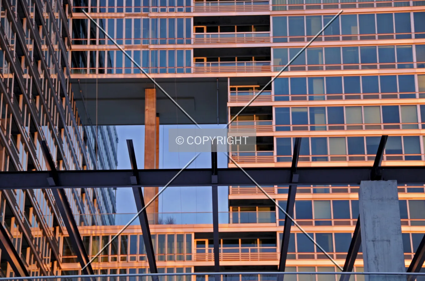 Trellis and western facade of the Elm Tower, illuminated with the setting sun piercing through the clouds