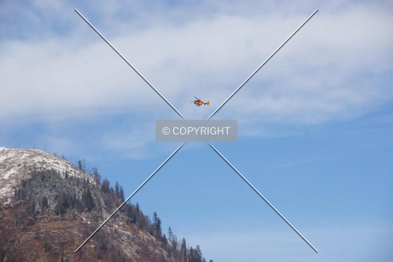 A helicopter is flying over a hill