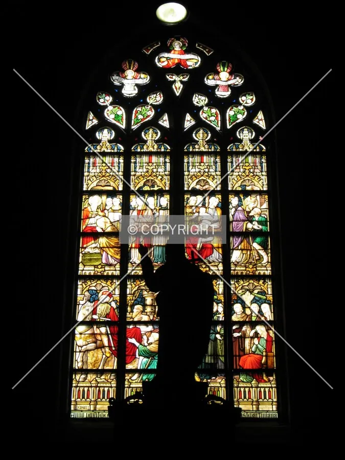 Window above the main porch with a statue of Christ in front