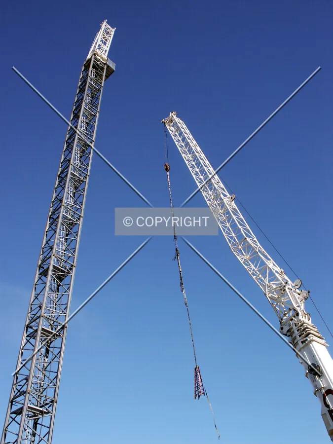 Looking up at the tower crane stem and mobile crane from the west