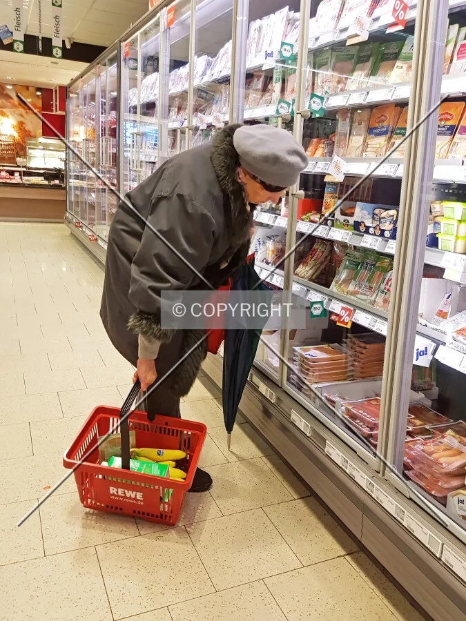 Old lady lifting a shopping basket