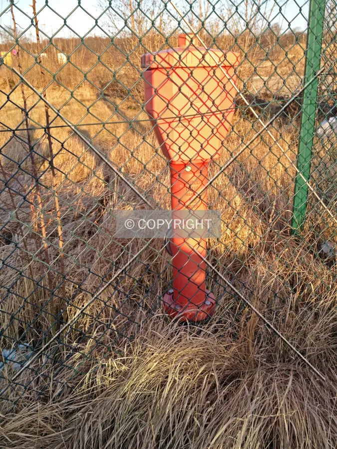 A fire hydrant behind a fence