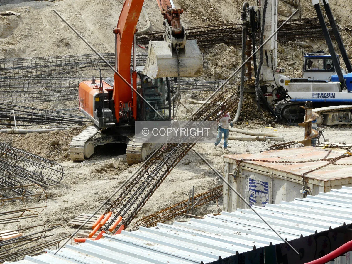Digger lifting rebars to put them in caisson's hole