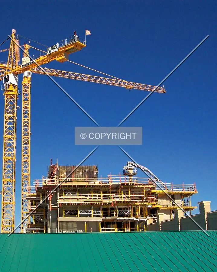 View of the building rising above the existing parking garage to the south