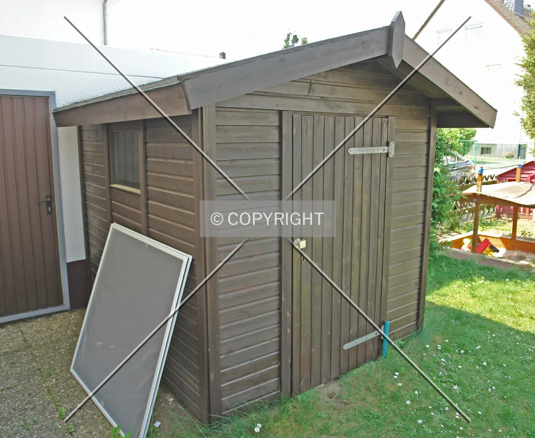 A small and dark brown garden hut