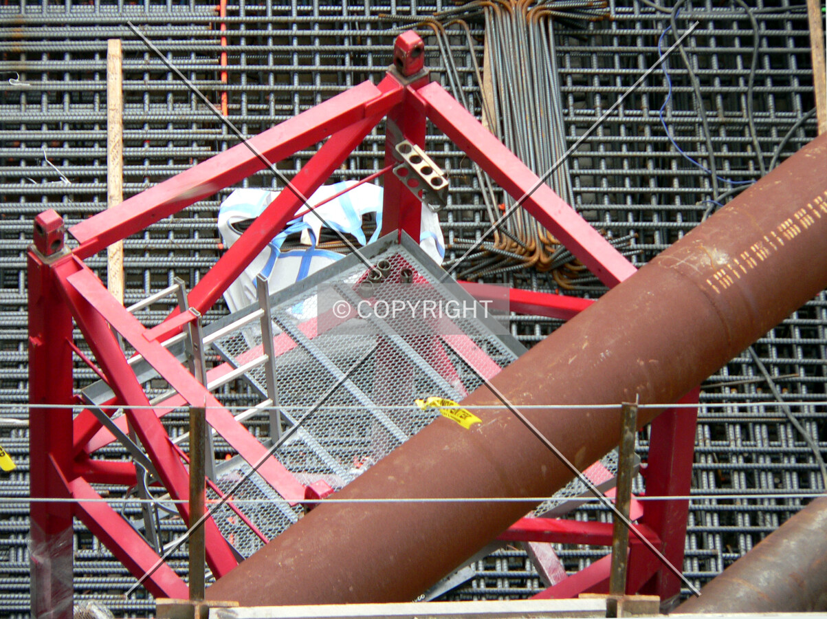 Base of the tower crane visible sitting on top of the rebar cage for the concrete mat