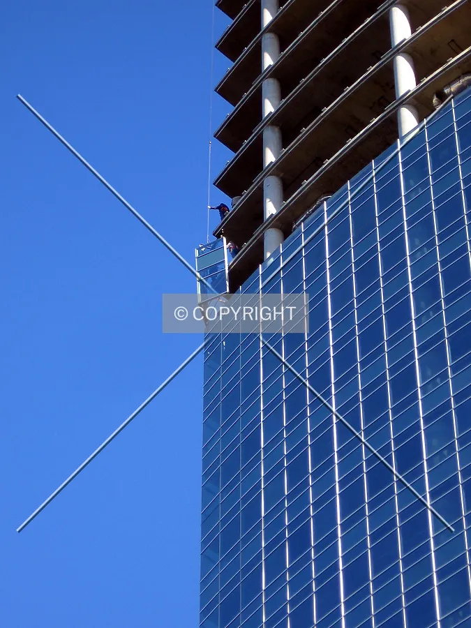 Workers placing a section of the curtain wall
