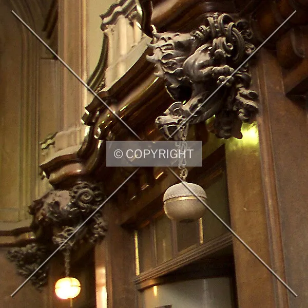 Grotesque figures holding lamps from their mouths