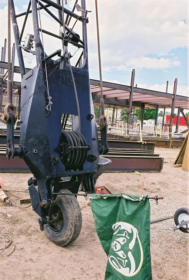 Tip of the crane boom resting on the ground with a CSU flag