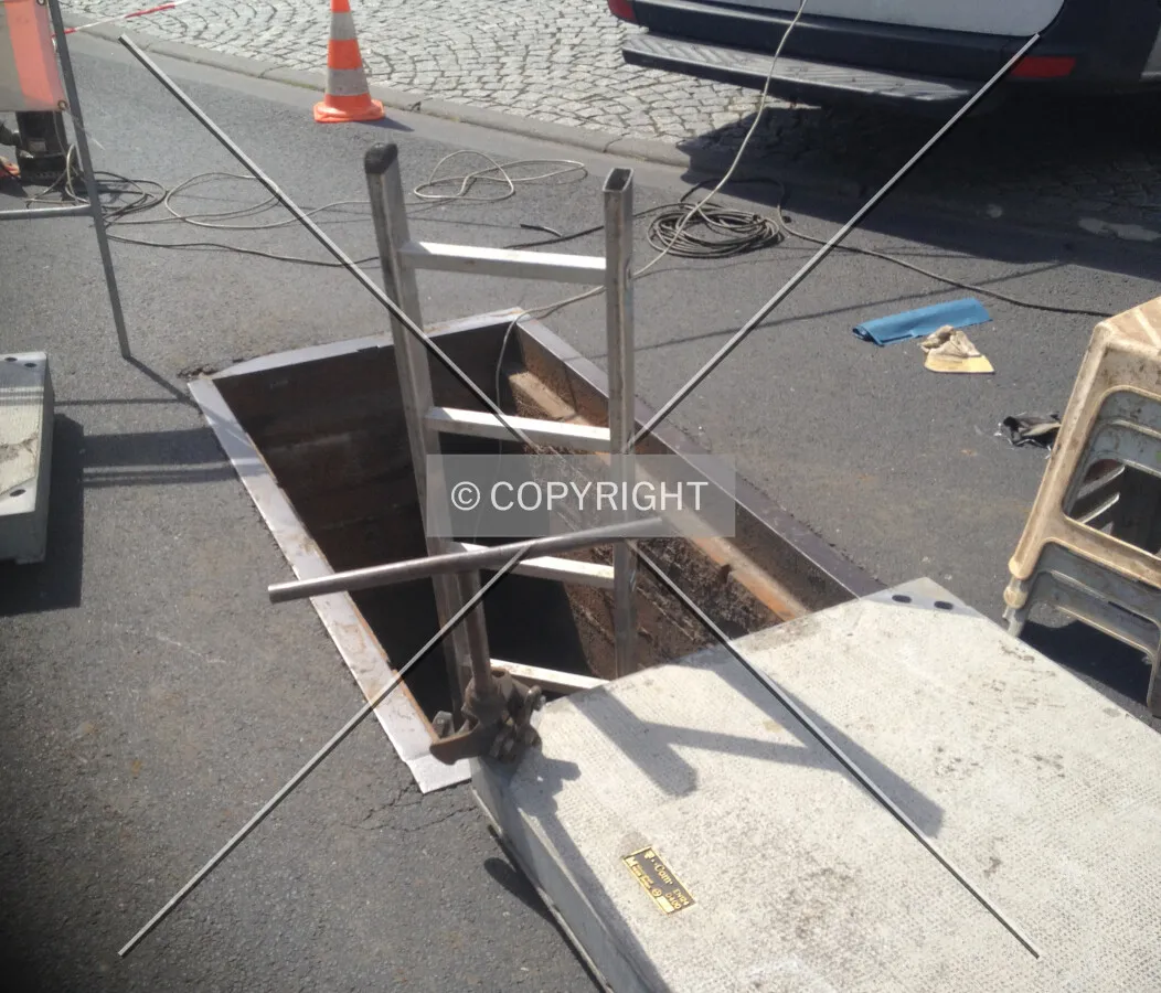 A construction site; a telecom company is repairing network connections under the street