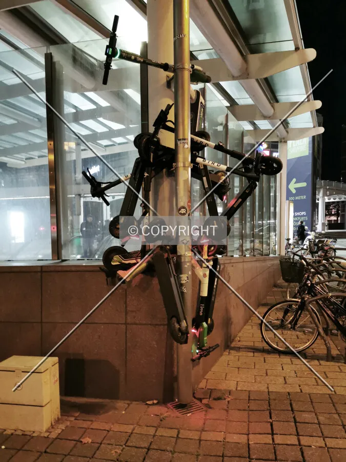 eScooters stacked at a lamp post