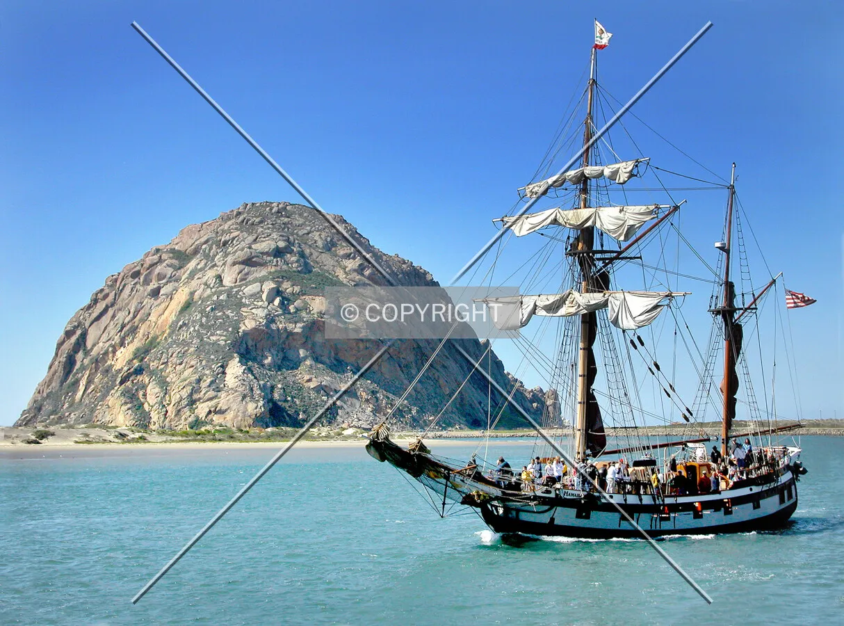 Morro Rock with a passing sailing ship